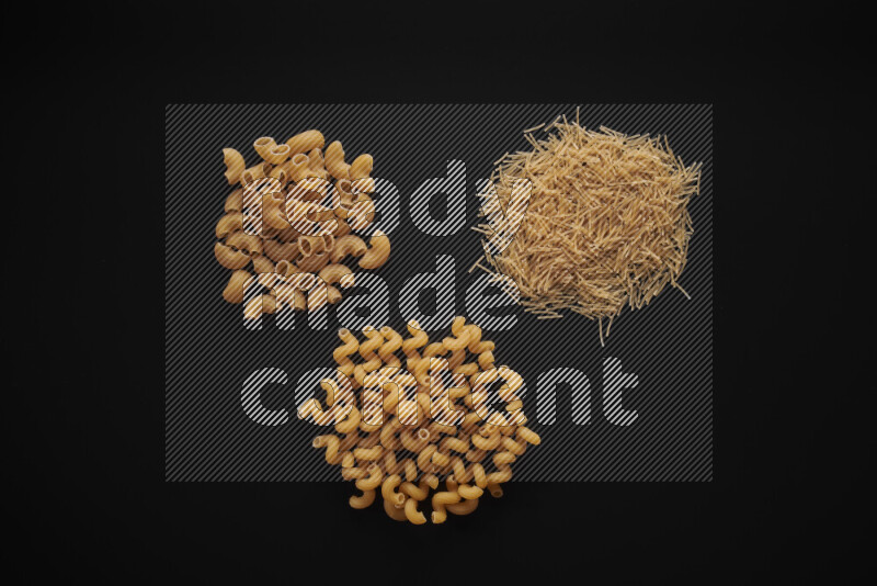 Different pasta types in bunches on black background