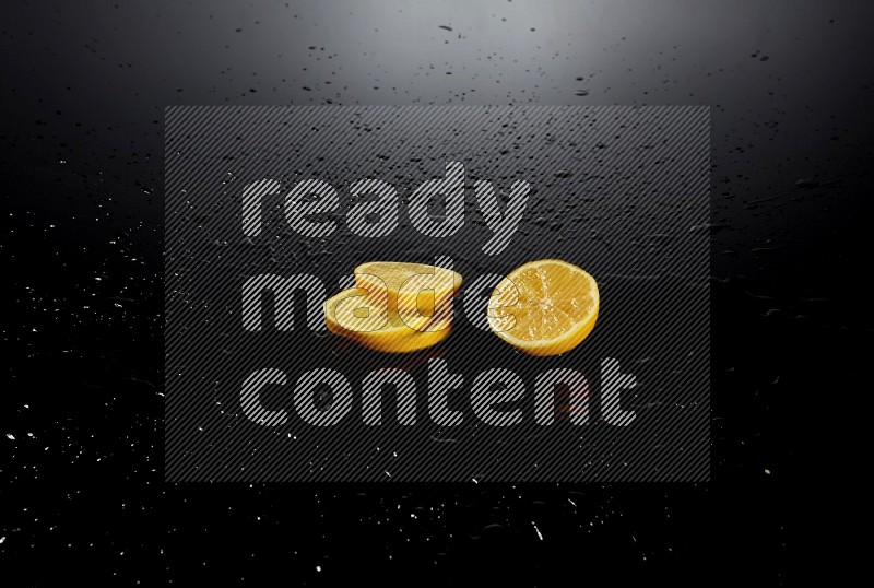 Lemon slices with water drops, and droplets on black background