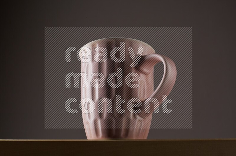 Low angle shot of a pink cup on grey background