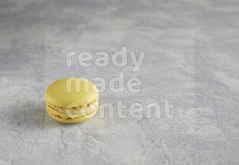 45º Shot of Yellow Lime macaron on white marble