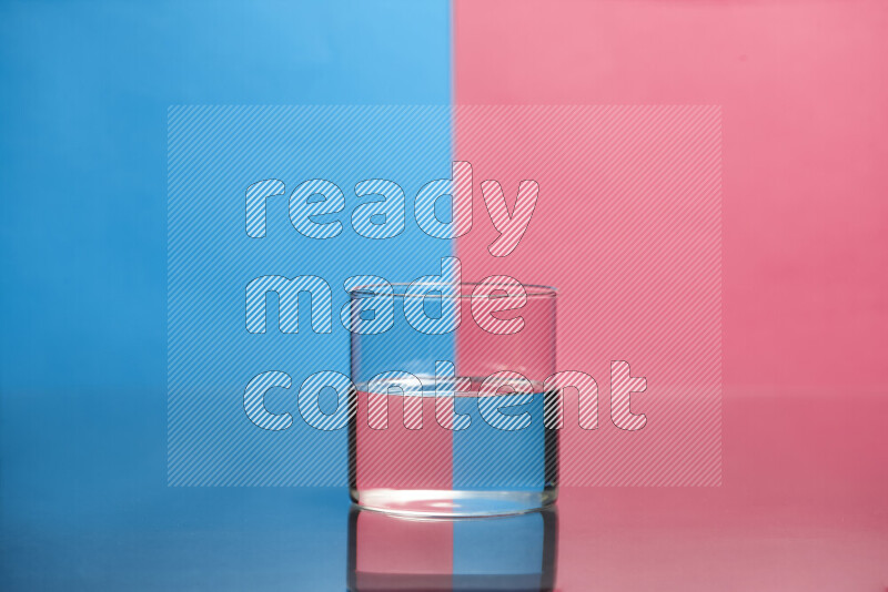 The image features a clear glassware filled with water, set against blue and pink background