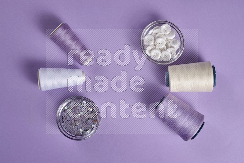 White sewing supplies on purple background