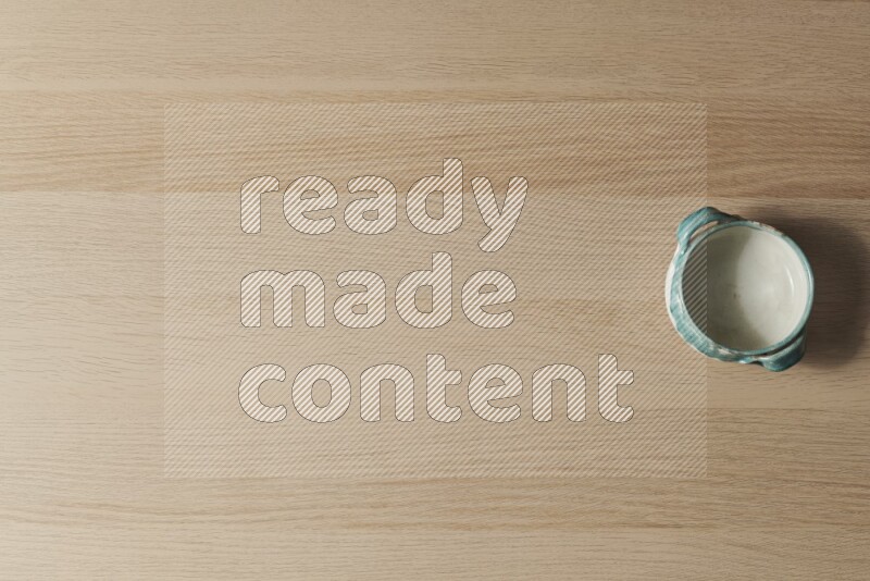 وعاء فخاري متعدد الألوان على خلفية خشبية فاتحة