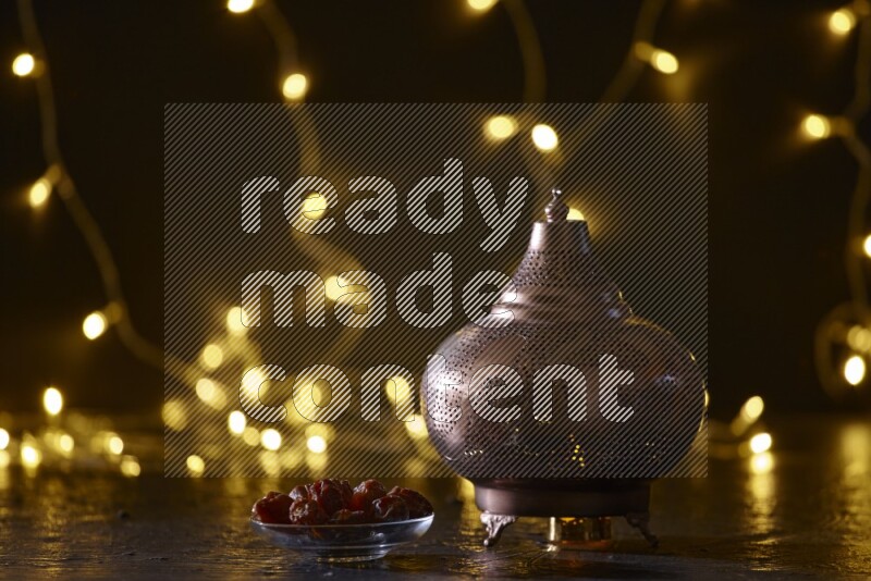 A traditional ramadan lantern surrounded by glowing fairy lights in a dark setup