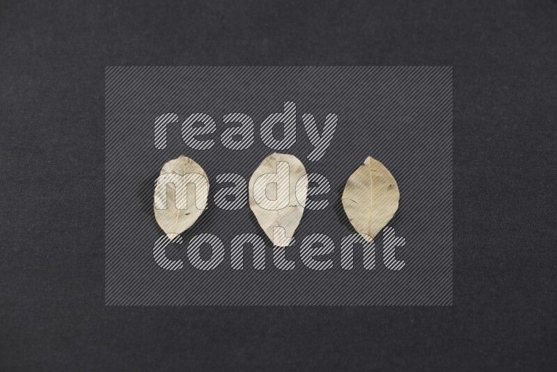 Dried bay leaves on black flooring