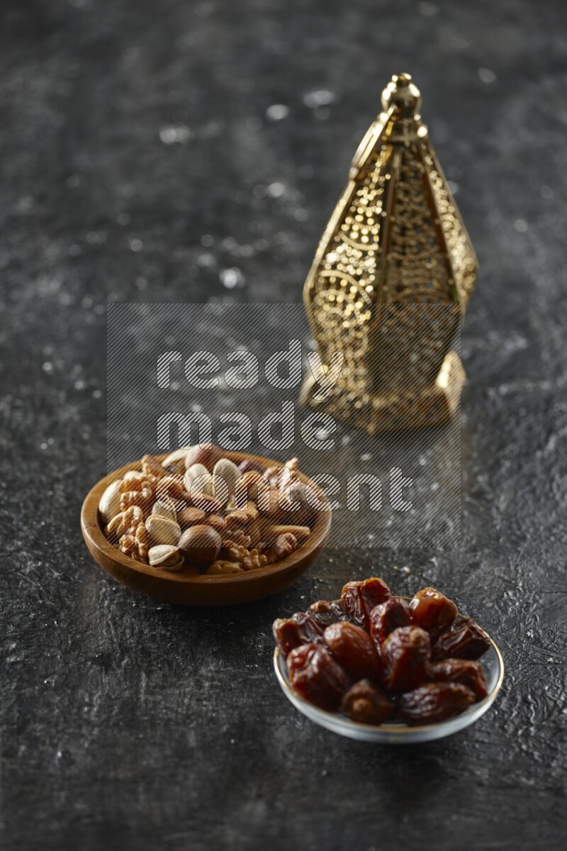 A golden lantern with different drinks, dates, nuts, prayer beads and quran on textured black background