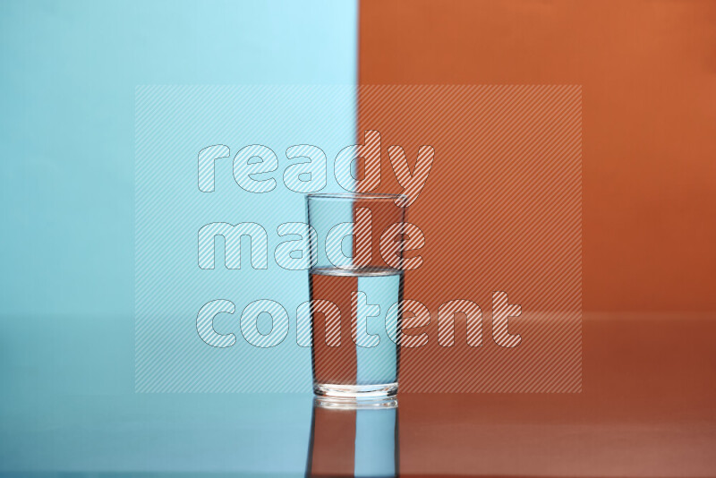 The image features a clear glassware filled with water, set against light blue and dark orange background