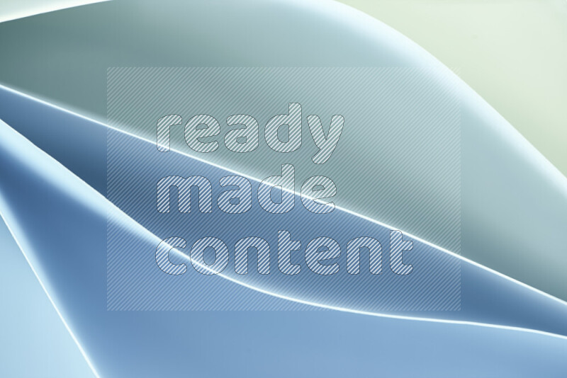 هذه الصورة تعرض تكوين فن الورق التجريدي مع منحنيات ورقية بتدرجات اللون الأخضر والأزرق المكونه بواسطة الضوء الملون