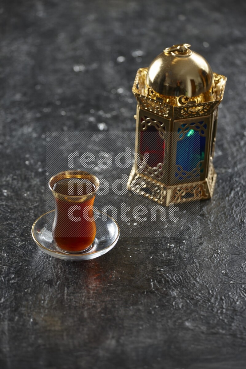 A golden lantern with different drinks, dates, nuts, prayer beads and quran on textured black background