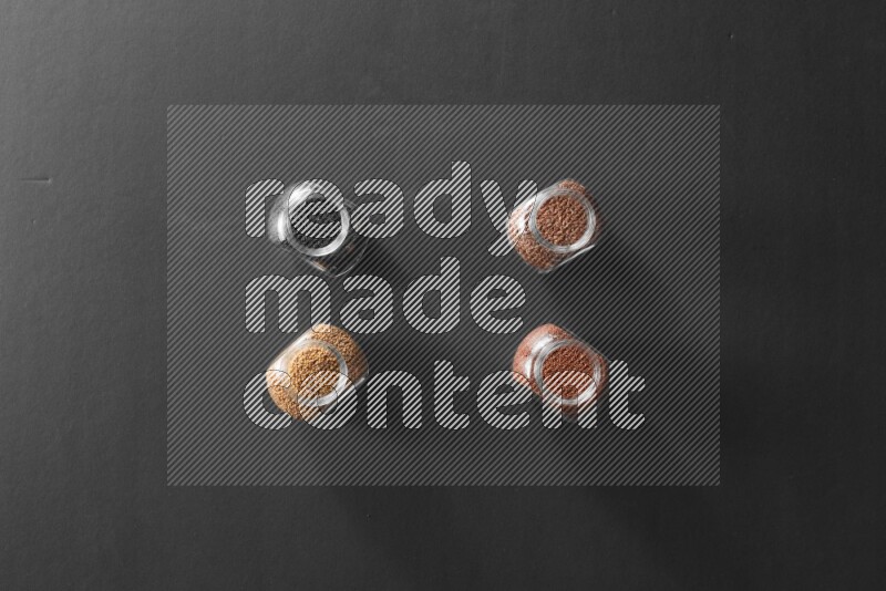 حبة البركة و حبوب الخردل وحبوب الكتان وحب الرشاد في أوعية زجاجية علي خلفية سوداء