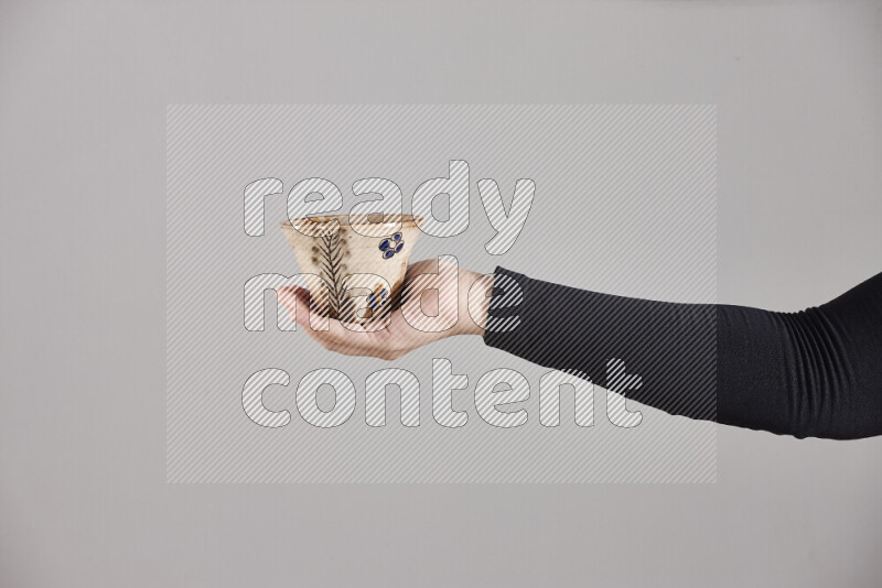 امرأة ترتدي عباءة سوداء تحمل أدوات فخارية مختلفة في أوضاع متعددة