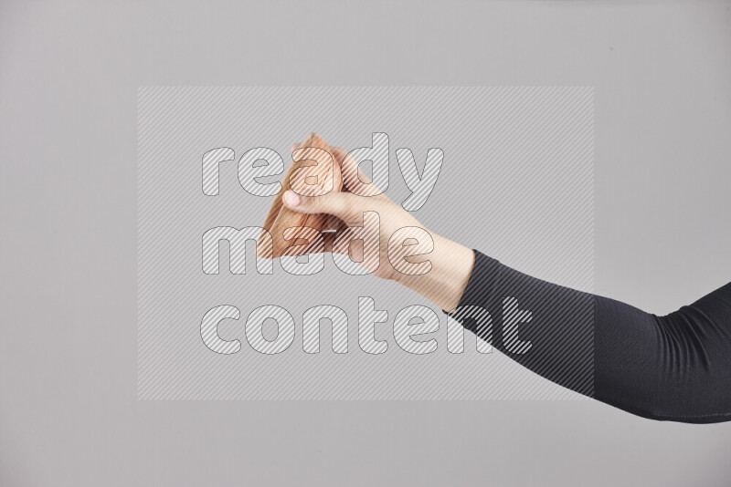 A woman in black abaya holding different wooden essentials in different positions