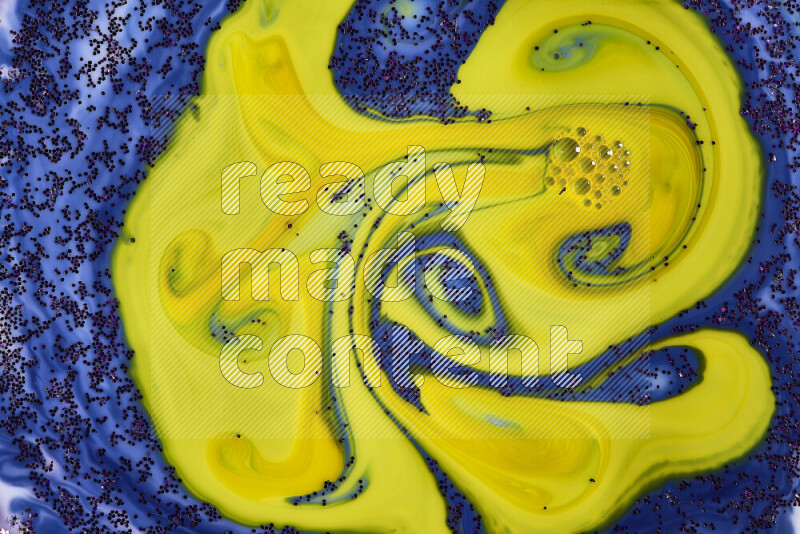 A close-up of sparkling purple glitter scattered on swirling blue and yellow background