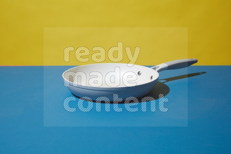 white pan on yellow and Blue background