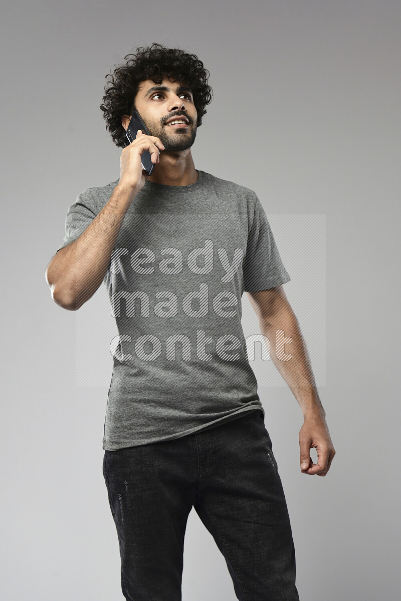 A man wearing casual standing and talking on the phone on white background