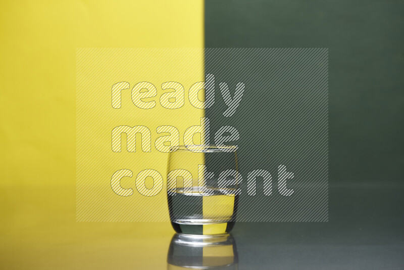 The image features a clear glassware filled with water, set against yellow and dark green background