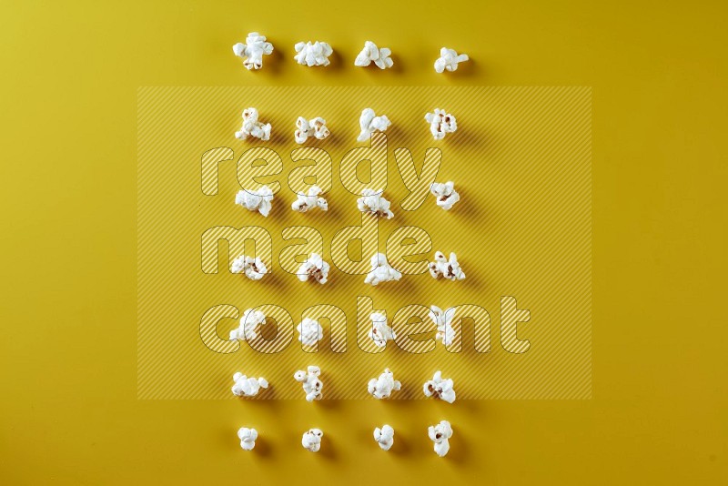 Popcorn flakes on a yellow background in different angles