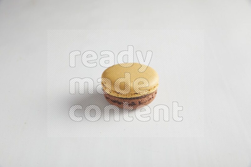 45º Shot of Yellow and Brown Chai Latte macaron on white background