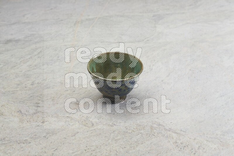 A multicolored pottery bowl on grey marble background