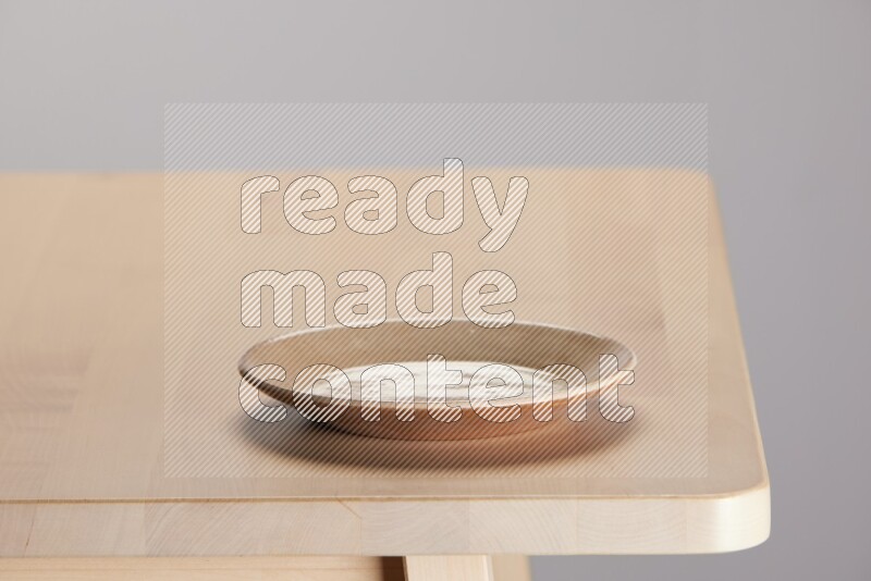 multi-colored pottery Plate on a wooden table edge