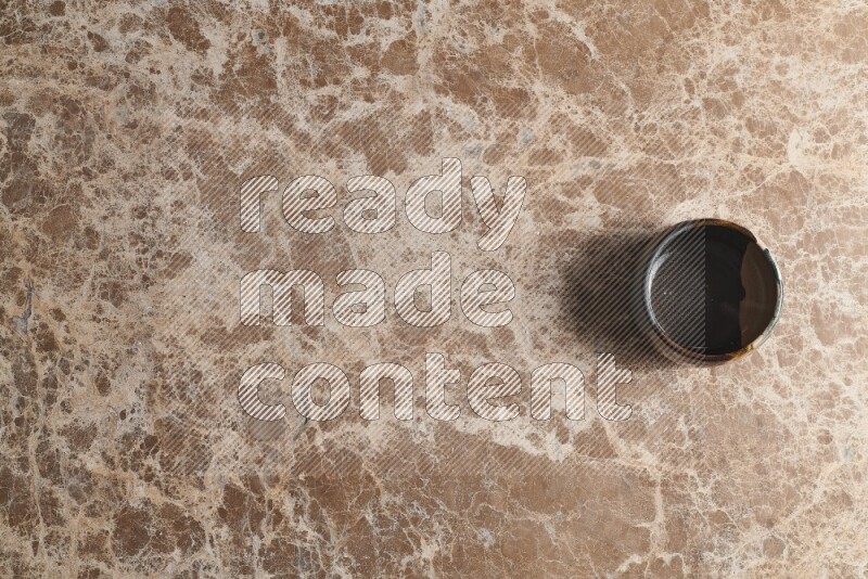 A multicolored pottery bowl on beige marble background