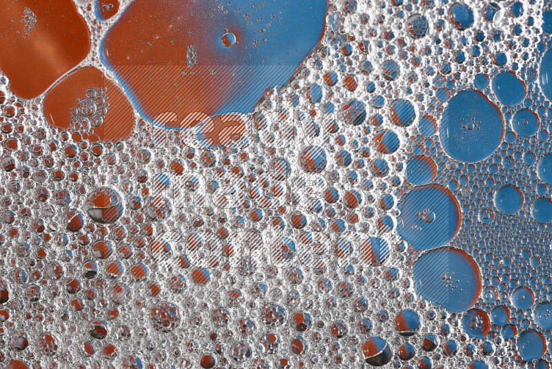 لقطات مقربة لفقاعات الصابون وقطرات الماء على خلفية باللون البرتقالي والأزرق