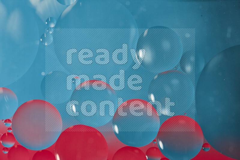 لقطات مقربة لفقاعات من الزيت على سطح الماء باللون الأزرق والوردي