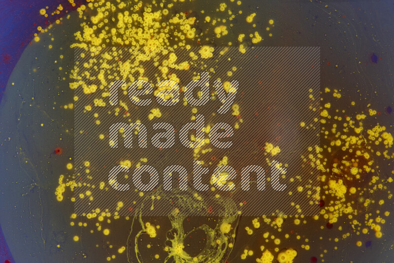 تلتقط الصورة تناثرا للطلاء الأصفر والأحمر علي خلفية زرقاء