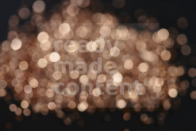 قطع زجاجية برونزية لامعة متناثرة على خلفية سوداء