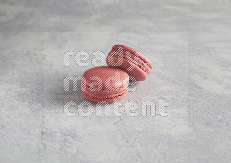 45º Shot of two Pink Raspberry macarons  on white  marble background
