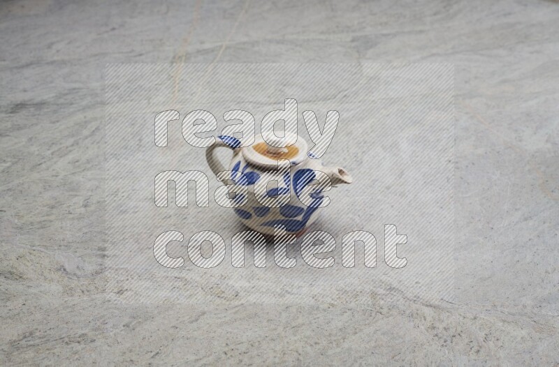A pottery teapot on grey marble background