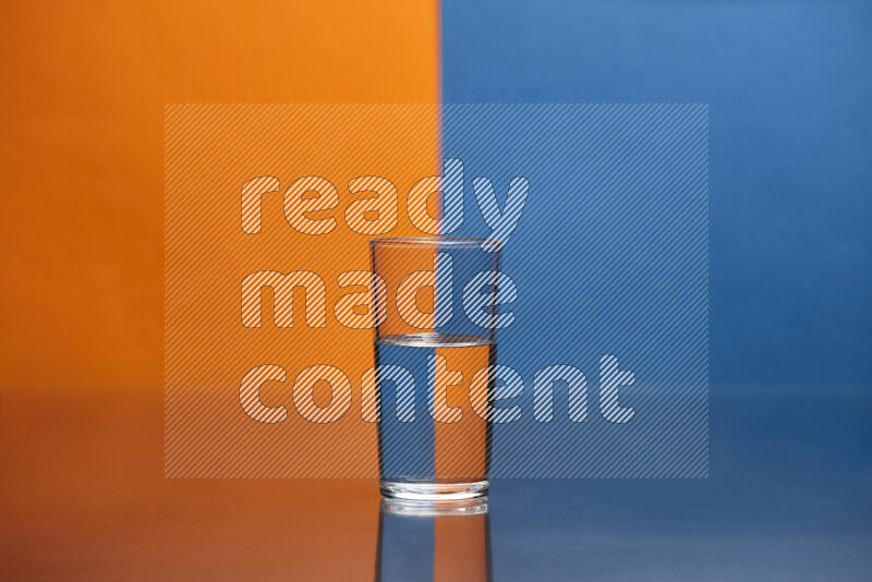 تظهر الصورة أواني زجاجية ممتلئة بالماء موضوعة على خلفية من اللونين البرتقالي والأزرق