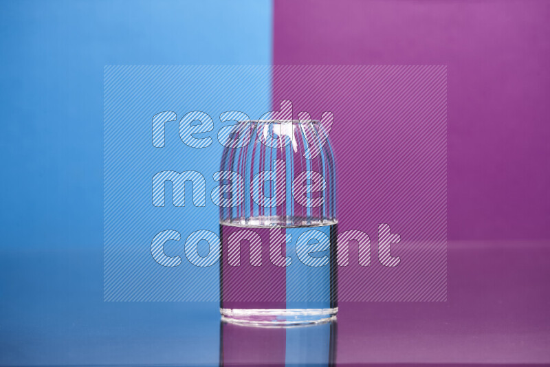 The image features a clear glassware filled with water, set against blue and purple background