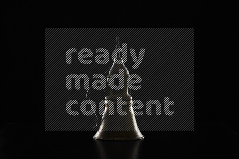 A turkish coffee pot with colored rim light against black background