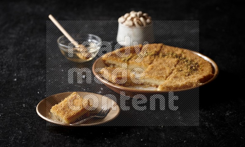 Konafa with nuts and honey in a dark setup