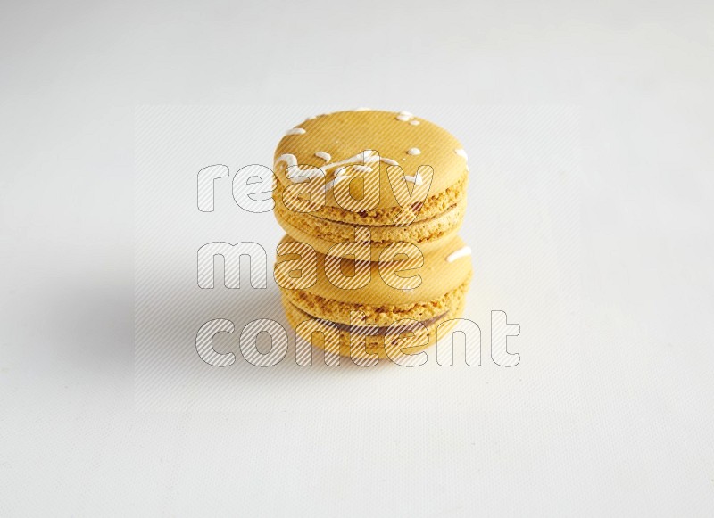 45º Shot of two Yellow Piña Colada macarons on white background