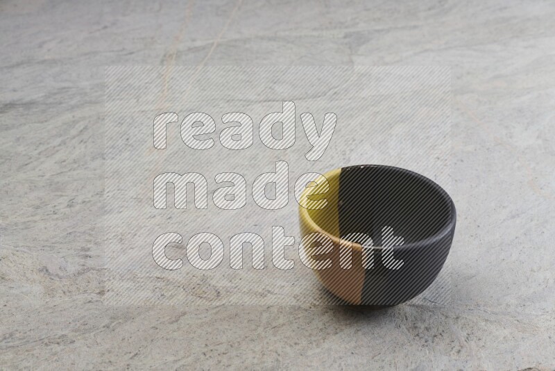 A multicolored pottery bowl on grey marble background