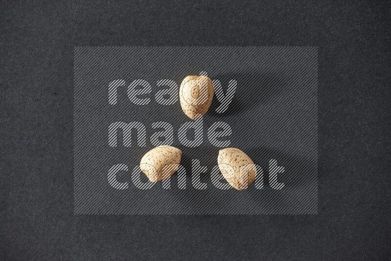 3 almonds on a black background in different angles