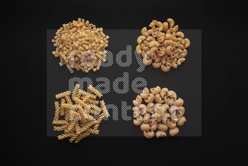 Different pasta types in bunches on black background