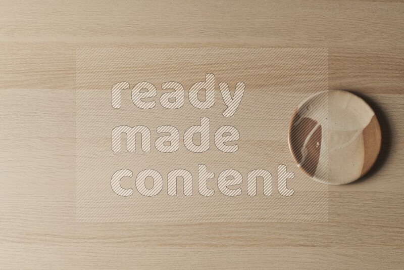 صحن فخاري متعدد الألوان على خلفية خشبية فاتحة