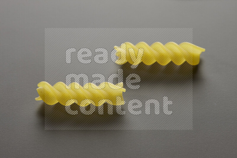 Fusilli pasta on grey background
