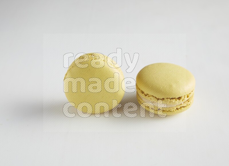 45º Shot of two Yellow Lime macarons on white background