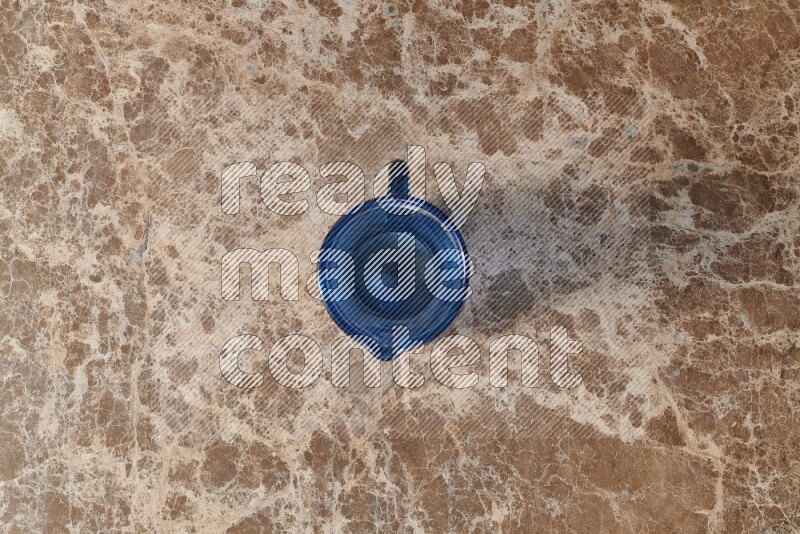 إبريق زجاجي فارغ على خلفية من الرخام البيج