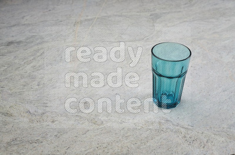 A Turquoise Glass On Grey Marble Flooring