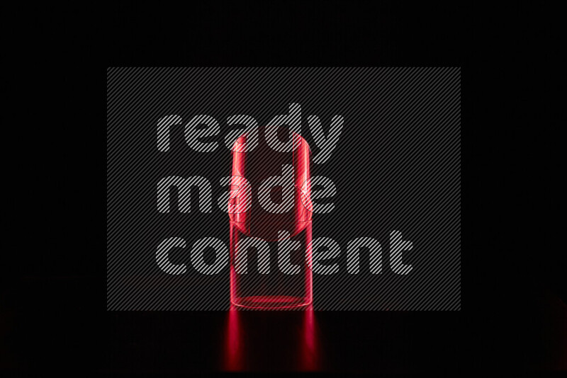 Glassware with rim light in red against black background