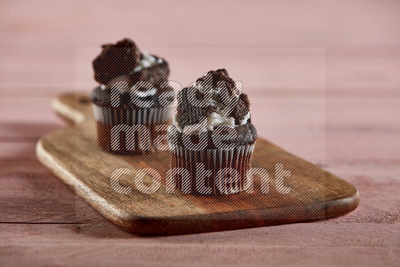 Chocolate mini cupcake topped with oreo on a wooden board