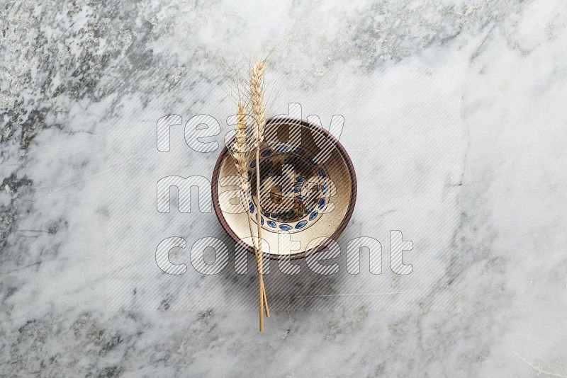 Wheat stalks on Decorative Pottery Plate on grey marble flooring, Top view