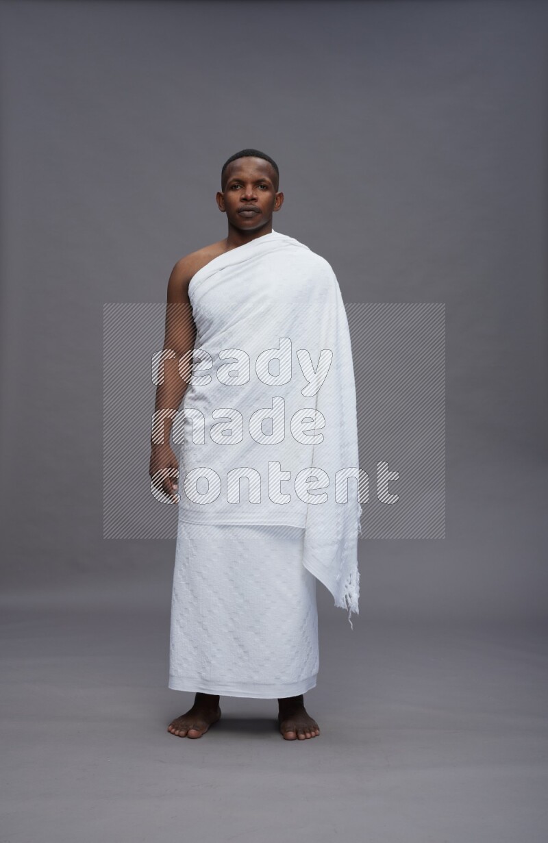 A man wearing Ehram Standing Interacting with the camera on gray background