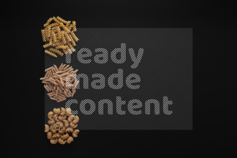 Different pasta types in 3 bunches on black background