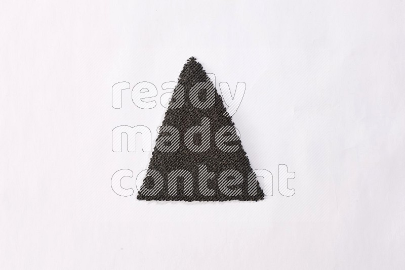 Black seeds in a triangle shape on a white flooring